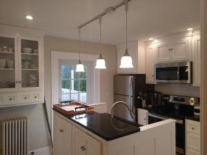 a kitchen with white cabinets and a black counter top at Rare Stonington Borough point in Stonington