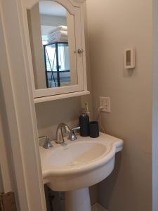 une salle de bain avec un lavabo et un miroir dans l'établissement Rare Stonington Borough point, à Stonington