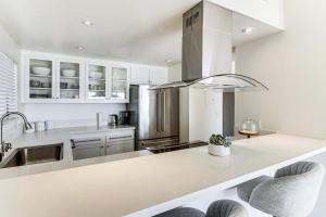 een keuken met witte kasten en een aanrechtblad bij Steps to Sand and Surf! Snowbird Haven in Malibu in Solromar