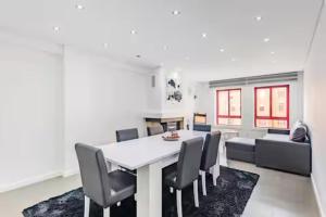 Un comedor con una mesa y sillas blancas. en Refugio dos Beijinhos, en Leça da Palmeira