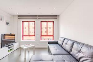 Una sala de estar con un sofá y un televisor. en Refugio dos Beijinhos, en Leça da Palmeira