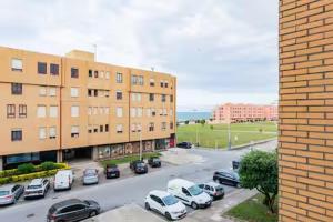 Un estacionamiento con autos estacionados frente a un edificio. en Refugio dos Beijinhos, en Leça da Palmeira