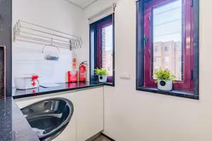 Un baño con lavabo y dos ventanas. en Refugio dos Beijinhos, en Leça da Palmeira 35 fotos más