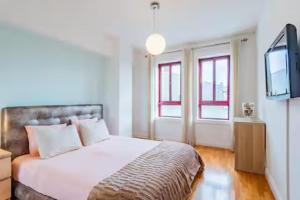 Un dormitorio con una cama y un televisor de pantalla plana. en Refugio dos Beijinhos, en Leça da Palmeira