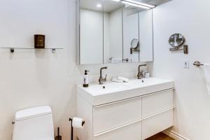 een witte badkamer met een wastafel en een spiegel bij Steps to Sand and Surf! Snowbird Haven in Malibu in Solromar +21 foto's