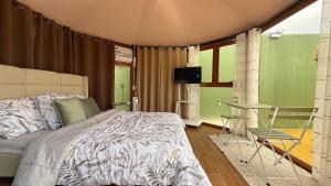 a bedroom with a bed and a table in it at Rosa del Sol - Entire Private Villa with Pool in Calasiao +14 photos