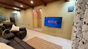 a living room with a netflix sign on the wall at Rosa del Sol - Entire Private Villa with Pool in Calasiao