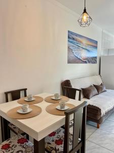 ein Esszimmer mit Tisch und Stühlen und einer Couch in der Unterkunft Lindo apartamento! 2 quartos com suíte, churrasqueira, garagem in Florianópolis