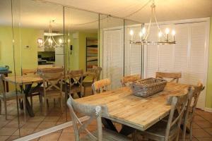 a dining room with a wooden table and chairs at Phoenix 1013 in Romar Beach