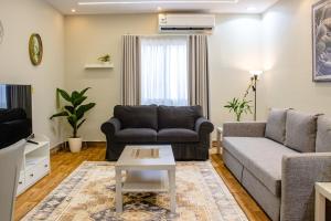 a living room with a couch and a table at Waha Grand Residance in Medina
