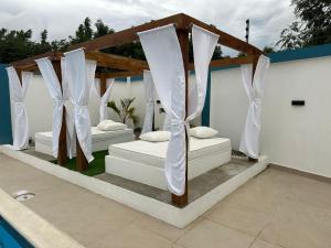 two beds under a gazebo next to a pool at Residencial HH in Santiago de los Caballeros