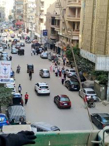a busy city street filled with cars and people at القوميه 