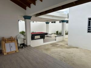 a patio with a pool table in a white building at Residencial HH in Santiago de los Caballeros