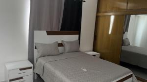 a small bedroom with a bed and a mirror at Residencial HH in Santiago de los Caballeros +10 photos
