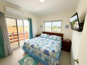 a bedroom with a bed and a tv and a window at Ocean Breeze in Oranjestad +59 photos
