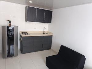 a kitchen with a sink and a refrigerator and a chair at La Mesa Suites - Hermosa vista in La Mesa +28 photos