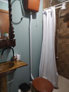 a bathroom with a toilet and a shower curtain at Cabana Beija Flor, a nest in nature in Tijucas +34 photos