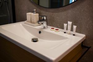 a white sink in a bathroom with a mirror at Siedlisko 3 Stodoły Bałtów - SPA w naturze in Bałtów