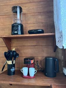 a shelf with two coffee cups and a blender at Cabana Beija Flor, a nest in nature in Tijucas