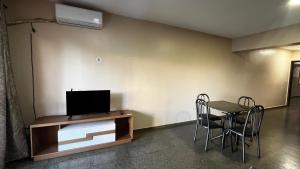a room with a tv and a table and chairs at Amplio y cómodo apartamento con bella vista en pleno centro in Ciudad del Este