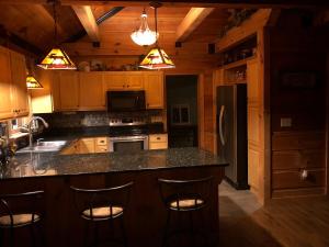 eine Küche mit Holzschränken und eine Insel mit Barhockern in der Unterkunft Beautiful Secluded Log Cabin in Cleveland + 36 Fotos