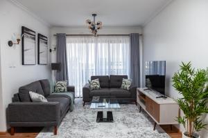 a living room with two couches and a tv at Apartment One bedroom Nairobi in Nairobi