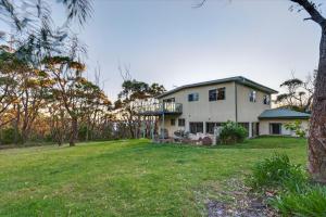 a large white house with a balcony on a yard at Kareelah in Tomakin