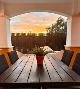 a wooden table with a potted plant on a patio at Villa Alegre - 2 bed villa with private heated pool on Mar Menor Golf - family friendly in Torre-Pacheco