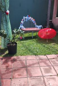a bench and two umbrellas sitting on the grass at Petricor Casa de Temporada COP30 in Belém