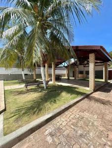 a park with a bench and a palm tree at Casa em porto da dunas in Aquiraz