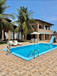a swimming pool in front of a house at Casa em porto da dunas in Aquiraz