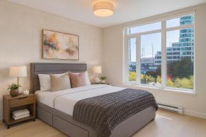 a bedroom with a large bed and a large window at Convenient Coal Harbour 2BR Steps to Seawall and SkyTrain in Vancouver