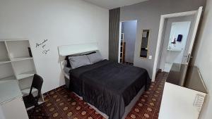 a small bedroom with a bed and a chair at Apart Novidade do verao in Rio de Janeiro +29 photos