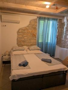 a bedroom with two beds and a stone wall at Villa Piazza grande in Fažana