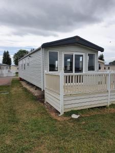 een witte stacaravan met een wit hek bij Flamingo land holiday home in Kirby Misperton