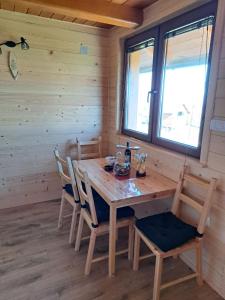 a dining room with a wooden table and chairs at Fruškogorske brvnare in Sremski Karlovci