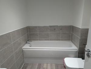 a bathroom with a white tub and a toilet at Double Room Roslin Near Edinurgh City in Roslin +1 photo