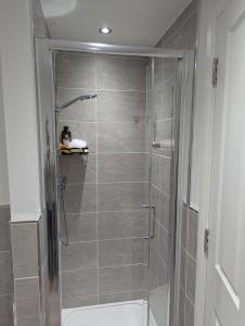a shower with a glass door in a bathroom at 3 bed spacious room in a new build house in Roslin