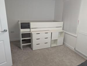 a bedroom with a white desk and a shelf at 3 bed spacious room in a new build house in Roslin