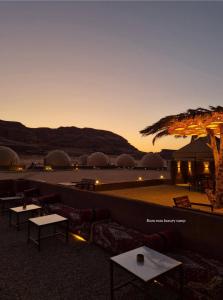 a view of a desert with tables and a sunset at Rum ROZA luxury Camp in Wadi Rum