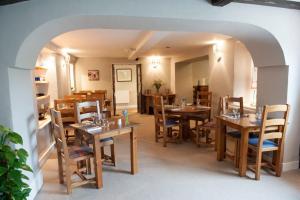 ein Esszimmer mit Holztischen und Stühlen in der Unterkunft Pheasant Inn in Kirkby Lonsdale