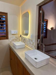 a bathroom with a white sink and a mirror at Matteo & Matteo Hostel Boutique in Pipa +46 photos