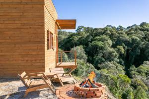 Refúgio na Serra c/ Vista Linda VST016 في São Paulo dos Pinhais: كابينة مع حفرة نار ومنصة وكراسي