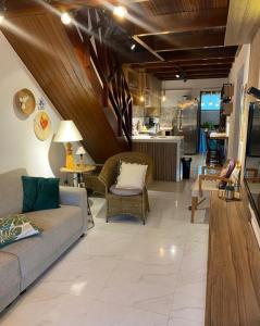 a living room with a couch and chairs and a kitchen at Chalé aconchegante in Gravatá +24 photos