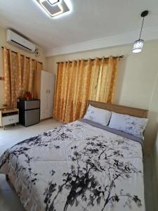 a bedroom with a bed with a black and white comforter at Compostela Guest Room #1 Terrace, Rooftop, Netflix, WiFi in Compostela +18 photos