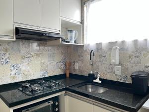 a kitchen with a sink and a stove at Casa da Lelê in Vila Velha +15 photos