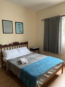 ein Schlafzimmer mit einem Bett mit zwei Handtüchern darauf in der Unterkunft Casa da Lelê in Vila Velha