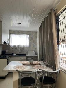 eine Küche mit einem Tisch und 2 Stühlen in der Unterkunft Casa da Lelê in Vila Velha