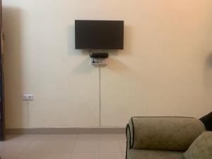 Una sala de estar con un sofá y un televisor en la pared. en The Emerald House, en Varanasi