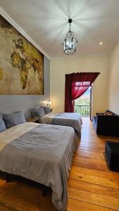 two beds in a room with a map on the wall at Casa Hibiscus Boutique Hotel in Cuenca